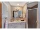 Well-lit bathroom with a marble countertop, framed mirror, and walk-in shower at 2406 Breakwater Cir, Sarasota, FL 34231