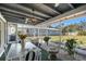 Bright screened-in lanai featuring a dining set and cozy seating area with a tranquil backyard view at 2406 Breakwater Cir, Sarasota, FL 34231