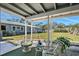 Relaxing screened-in lanai with comfortable seating and serene views of the expansive backyard at 2406 Breakwater Cir, Sarasota, FL 34231