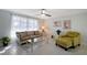 Comfortable living room featuring a floral sofa, accent chair, and ample natural light at 2406 Breakwater Cir, Sarasota, FL 34231