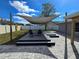 Modern backyard deck with shade sail, stone pavers and comfortable seating at 3507 65Th Avenue E Cir, Sarasota, FL 34243