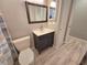 Bathroom featuring a sink with modern vanity, toilet, and a framed mirror at 3507 65Th Avenue E Cir, Sarasota, FL 34243