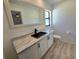 Modern bathroom featuring a sleek vanity with quartz countertop, black fixtures, and stylish flooring at 3507 65Th Avenue E Cir, Sarasota, FL 34243