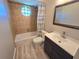 Cozy bathroom featuring a bathtub, sink, and a unique geometric window for natural light at 3507 65Th Avenue E Cir, Sarasota, FL 34243