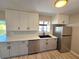 Stylish kitchen featuring white cabinets, stainless steel appliances, and a clear view of the pool at 3507 65Th Avenue E Cir, Sarasota, FL 34243