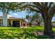 Manicured backyard featuring a screened in lanai and lush, green grass with mature landscaping at 3641 Gleneagle Dr # 12D, Sarasota, FL 34238