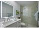Bright, renovated bathroom boasts a glass shower, single sink vanity with a solid surface countertop and under cabinet storage at 3641 Gleneagle Dr # 12D, Sarasota, FL 34238