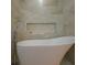 Close-up of a modern white standalone soaking tub with sleek chrome faucet and tiled accent wall niche at 3641 Gleneagle Dr # 12D, Sarasota, FL 34238