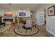 Open-concept dining area with a round wood table, unique patterned chairs, and a matching circular area rug at 3641 Gleneagle Dr # 12D, Sarasota, FL 34238