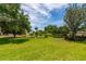 Expansive front lawn with scattered mature trees and landscaping features for outdoor enjoyment at 3641 Gleneagle Dr # 12D, Sarasota, FL 34238