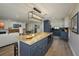 Open layout kitchen with a center island, dark blue cabinets, stone countertops, and stainless-steel appliances at 3641 Gleneagle Dr # 12D, Sarasota, FL 34238
