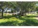 Beautiful green space with mature trees, charming bench, and well-manicured lawn in residential neighborhood at 3692 Glen Oaks Manor Dr, Sarasota, FL 34232
