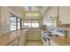 Well-lit kitchen offering white cabinetry, tile backsplash, and ample counter space with a pool view at 3692 Glen Oaks Manor Dr, Sarasota, FL 34232