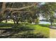 Scenic view of a lake surrounded by lush trees and green grass at 3692 Glen Oaks Manor Dr, Sarasota, FL 34232