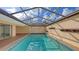Enclosed pool area featuring cool blue pool water, ample sunlight, and tiled trim accents at 3692 Glen Oaks Manor Dr, Sarasota, FL 34232