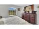 Bedroom with view of large sunlit window and a large dark wood dresser with artwork at 3791 Sesame St, North Port, FL 34287