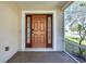 Inviting front porch with wood door framed by sidelights offering views of landscaped yard at 3831 Day Bridge Pl, Ellenton, FL 34222