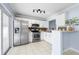 Modern kitchen featuring stainless steel appliances, white cabinets, and track lighting at 3831 Day Bridge Pl, Ellenton, FL 34222
