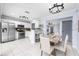 Open kitchen and dining area featuring white cabinets, stainless steel appliances, and modern lighting at 3831 Day Bridge Pl, Ellenton, FL 34222