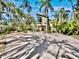 Stunning contemporary home boasts a striking facade surrounded by lush tropical landscaping and a spacious brick driveway at 3911 Roberts Point Rd, Sarasota, FL 34242