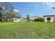 Expansive backyard with lush green lawn, mature trees, an outdoor kitchen, and a shed at 4045 Lisbon Pl, Sarasota, FL 34231