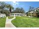 Spacious backyard featuring a pergola, outdoor grill, fire pit, lush green lawn, and mature trees at 4045 Lisbon Pl, Sarasota, FL 34231