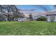 Large backyard with lush green lawn, mature trees, outdoor kitchen, and home exterior at 4045 Lisbon Pl, Sarasota, FL 34231