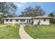 Backyard showcasing patio seating, outdoor grill, fire pit, lush green lawn, and mature trees at 4045 Lisbon Pl, Sarasota, FL 34231