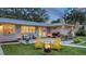 Charming backyard featuring a fire pit, patio with seating, outdoor grill, and lush green grass at 4045 Lisbon Pl, Sarasota, FL 34231