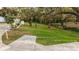 Large backyard with mature trees, green grass, and a charming hanging chair at 4045 Lisbon Pl, Sarasota, FL 34231
