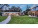 Expansive backyard features a lush lawn, patio area with furniture, and outdoor grill at 4045 Lisbon Pl, Sarasota, FL 34231