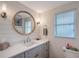 Stylish bathroom featuring a modern vanity with a round mirror, contemporary lighting, and elegant fixtures at 4045 Lisbon Pl, Sarasota, FL 34231