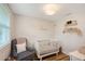 Bedroom with white ship lap, wood floors, white crib and gray rocking chair at 4045 Lisbon Pl, Sarasota, FL 34231