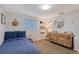 Charming bedroom features neutral walls, carpeted floor, natural wood dresser and blue bed spread at 4045 Lisbon Pl, Sarasota, FL 34231
