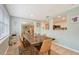 The dining room has pale green walls, a wood table and chairs, and an opening to the kitchen and playroom at 4045 Lisbon Pl, Sarasota, FL 34231