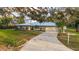 Home featuring a metal roof, long driveway, and well-maintained landscaping at 4045 Lisbon Pl, Sarasota, FL 34231