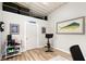 Bright exercise room features wood floors, shiplap walls, exercise bike and weight rack at 4045 Lisbon Pl, Sarasota, FL 34231
