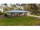 Well-maintained home with a metal roof, landscaping, and an attached garage at 4045 Lisbon Pl, Sarasota, FL 34231