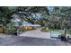 Gated driveway leading to a well-maintained home with a metal roof and manicured landscaping at 4045 Lisbon Pl, Sarasota, FL 34231