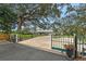 Charming single-story home featuring a gated driveway and mature trees at 4045 Lisbon Pl, Sarasota, FL 34231