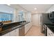 Modern kitchen featuring sleek countertops, white cabinets, stainless steel appliances, and wood floors at 4045 Lisbon Pl, Sarasota, FL 34231