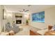Inviting living room with fireplace, ceiling fan, and ample natural light from large window at 4045 Lisbon Pl, Sarasota, FL 34231