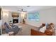 Comfortable living room features a fireplace, ceiling fan, and a large window for natural light at 4045 Lisbon Pl, Sarasota, FL 34231