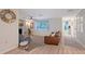 Bright living room with a fireplace, a ceiling fan, and a view of the yard through a large window at 4045 Lisbon Pl, Sarasota, FL 34231