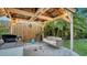 Outdoor kitchen area with built-in grill, dining area, patio swing, string lights, and lush landscaping at 4045 Lisbon Pl, Sarasota, FL 34231