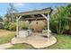 Outdoor kitchen and dining area with built-in grill, patio swing, and lush landscaping at 4045 Lisbon Pl, Sarasota, FL 34231