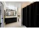 Bathroom with a black vanity, black framed mirror, and a shower with a black curtain at 4255 67Th Avenue E Cir, Sarasota, FL 34243