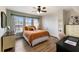 Bright bedroom with a decorative bed, wood floors, three windows, and a ceiling fan at 4255 67Th Avenue E Cir, Sarasota, FL 34243