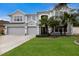 Charming two-story home with a three-car garage, well-manicured lawn, and mature palm trees at 4255 67Th Avenue E Cir, Sarasota, FL 34243