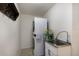 Laundry room with a stackable washer and dryer, a stainless steel sink, and shelving at 4255 67Th Avenue E Cir, Sarasota, FL 34243